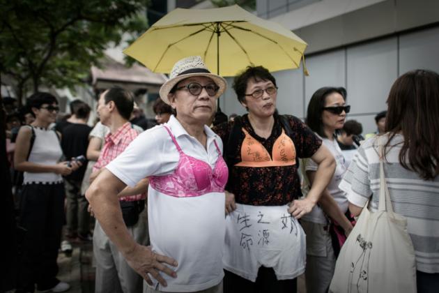 protesters wear bras during a demonstration outside the police headquarters in hong kong on august 2 2015 the demonstrators gathered in support of a hong kong woman who was sentenced to three and a half months jail for using her breast to bump a police officer during a protest photo afp