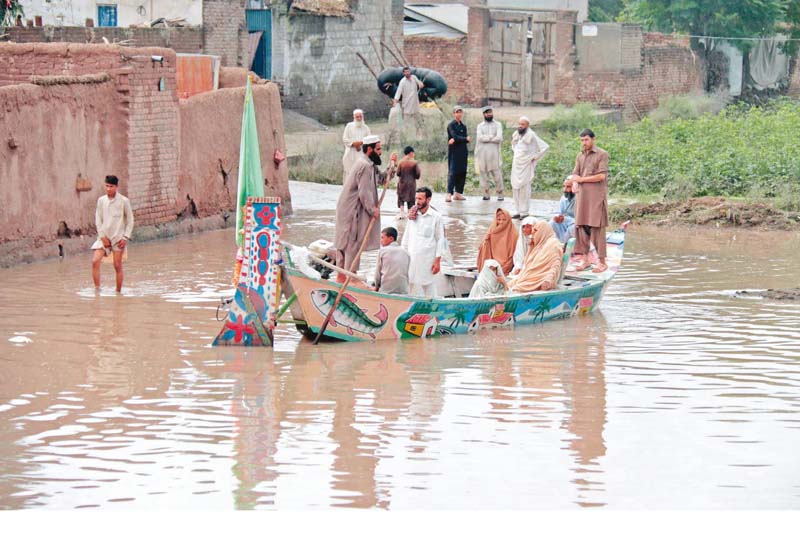 locals use a ferry to cross a stream of floodwater in akbarpura photo muhammad iqbal express