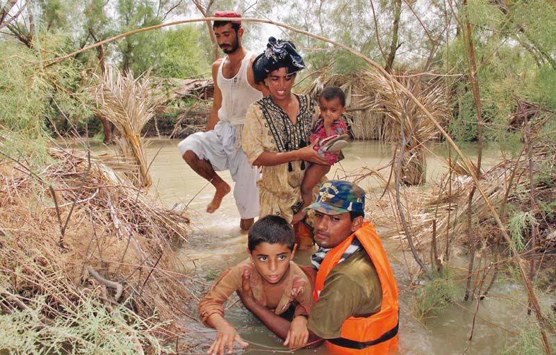 a family being rescued by a pakistan navy marine from an area of sindh devastated by flood water on sunday photo inp