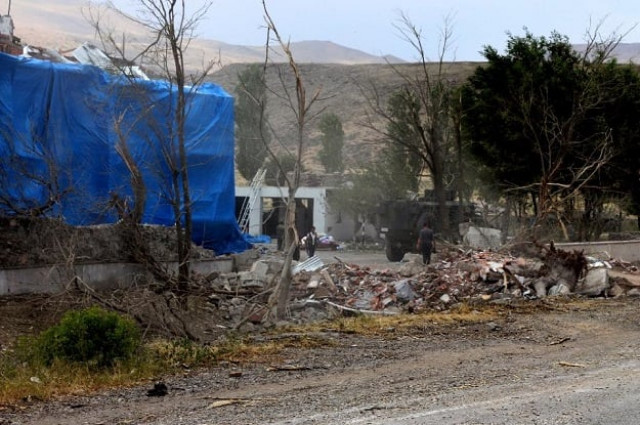 wreckage lies on the ground in front of a turkish military station covered by a tarp after a suicide atack on august 2 2015 photo afp