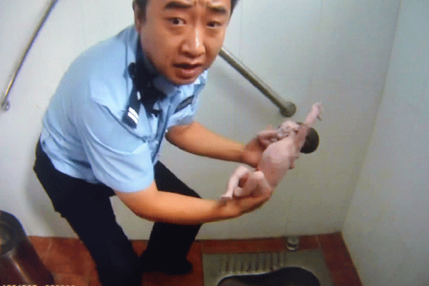 this frame grab of a police video taken on august 2 2015 shows a policeman holding an abandoned newborn baby in a public toilet in beijing a newborn baby girl was abandoned in a beijing public toilet and fell head first down the pipe reports said august 3 after her mother apparently gave birth in the facility photo afp