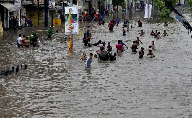 people walk through rain water following in lahore on july 21 2015 photo afp