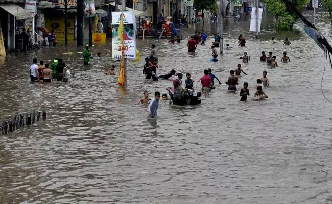 people walk through rain water following in lahore on july 21 2015 photo afp people walk through rain water following in lahore on july 21 2015 photo afp