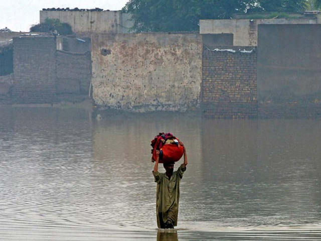 a man carries his belongings as he wades through a flooded area in nowshera district of khyber pakhtunkhwa photo afp a man carries his belongings as he wades through a flooded area in nowshera district of khyber pakhtunkhwa photo afp