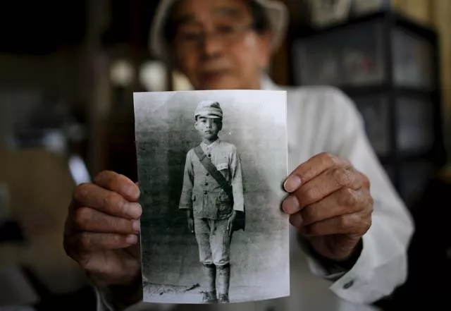 yoshiteru kohata a 86 year old nagasaki atomic bombing survivor and retired school teacher who returned to his home region of fukushima after world war two poses with a portrait taken when he was in middle school at his home in the town of miharu fukushima prefecture japan july 31 2015 photo reuters yoshiteru kohata a 86 year old nagasaki atomic bombing survivor and retired school teacher who returned to his home region of fukushima after world war two poses with a portrait taken when he was in middle school at his home in the town of miharu fukushima prefecture japan july 31 2015 photo reuters