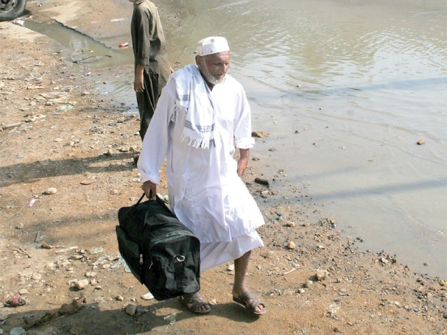 an elderly man exits haji camp in sultanabad near the us consulate where a 33 inch diameter pipeline burst flooding the road photo express