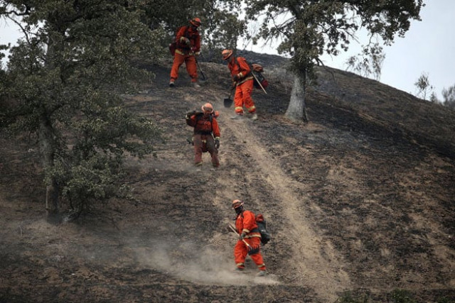 inmate firefighters hike down a hill as they mop up hot spots from the rocky on august 4 2015 near clearlake california photo afp inmate firefighters hike down a hill as they mop up hot spots from the rocky on august 4 2015 near clearlake california photo afp