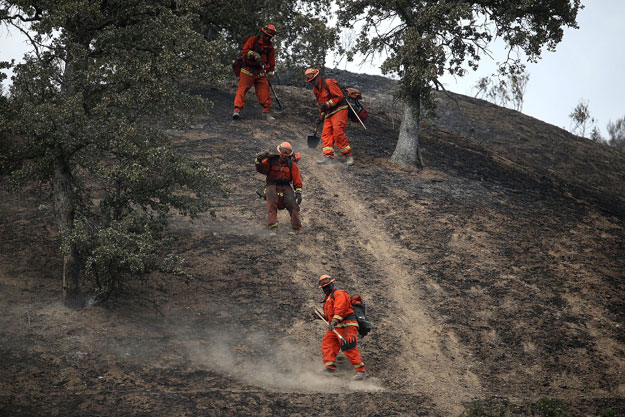 inmate firefighters hike down a hill as they mop up hot spots from the rocky on august 4 2015 near clearlake california photo afp