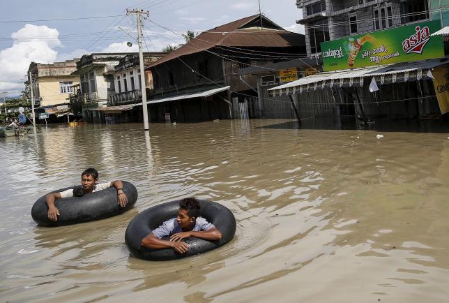 men wade along a flooded street at kalay township at sagaing division august 2 2015 photo reuters