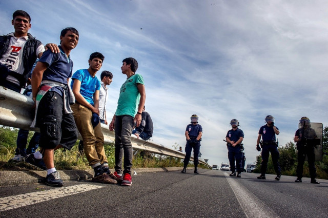 french riot police stand on a road to prevent migrants from reaching the road leading to the ferry port in calais northern france on august 5 2015 photoi afp french riot police stand on a road to prevent migrants from reaching the road leading to the ferry port in calais northern france on august 5 2015 photoi afp