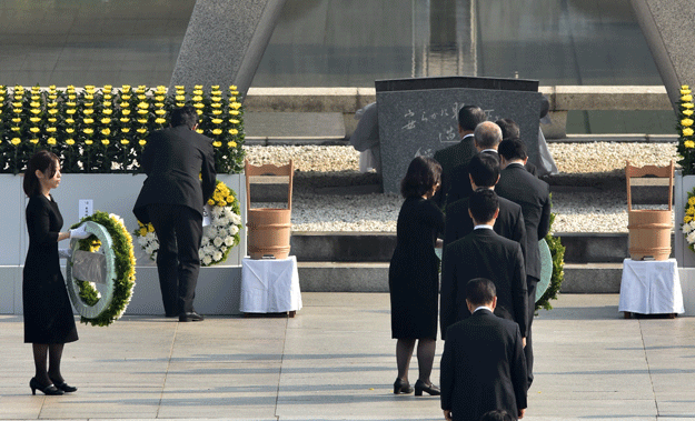 japanese prime minister shinzo abe 2nd l offers a wreath of flowers at the memorial cenotaph for victims of a 1945 atomic bombing during a memorial ceremony to mark the 70th anniversary at the hiroshima peace memorial park in western japan on august 6 2015 photo afp