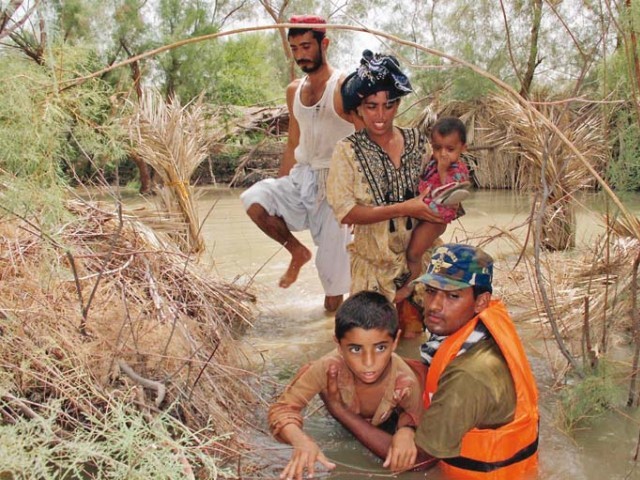 a family being rescued by a pakistan navy marine from an area of sindh devastated by flood water on sunday photo inp