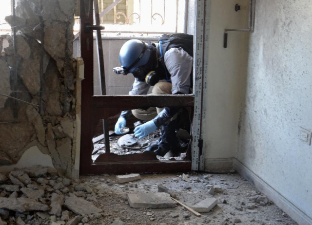 a united nations weapons expert collects samples during an investigation into a 2013 suspected chemical weapons strike near damascus photo afp a united nations weapons expert collects samples during an investigation into a 2013 suspected chemical weapons strike near damascus photo afp