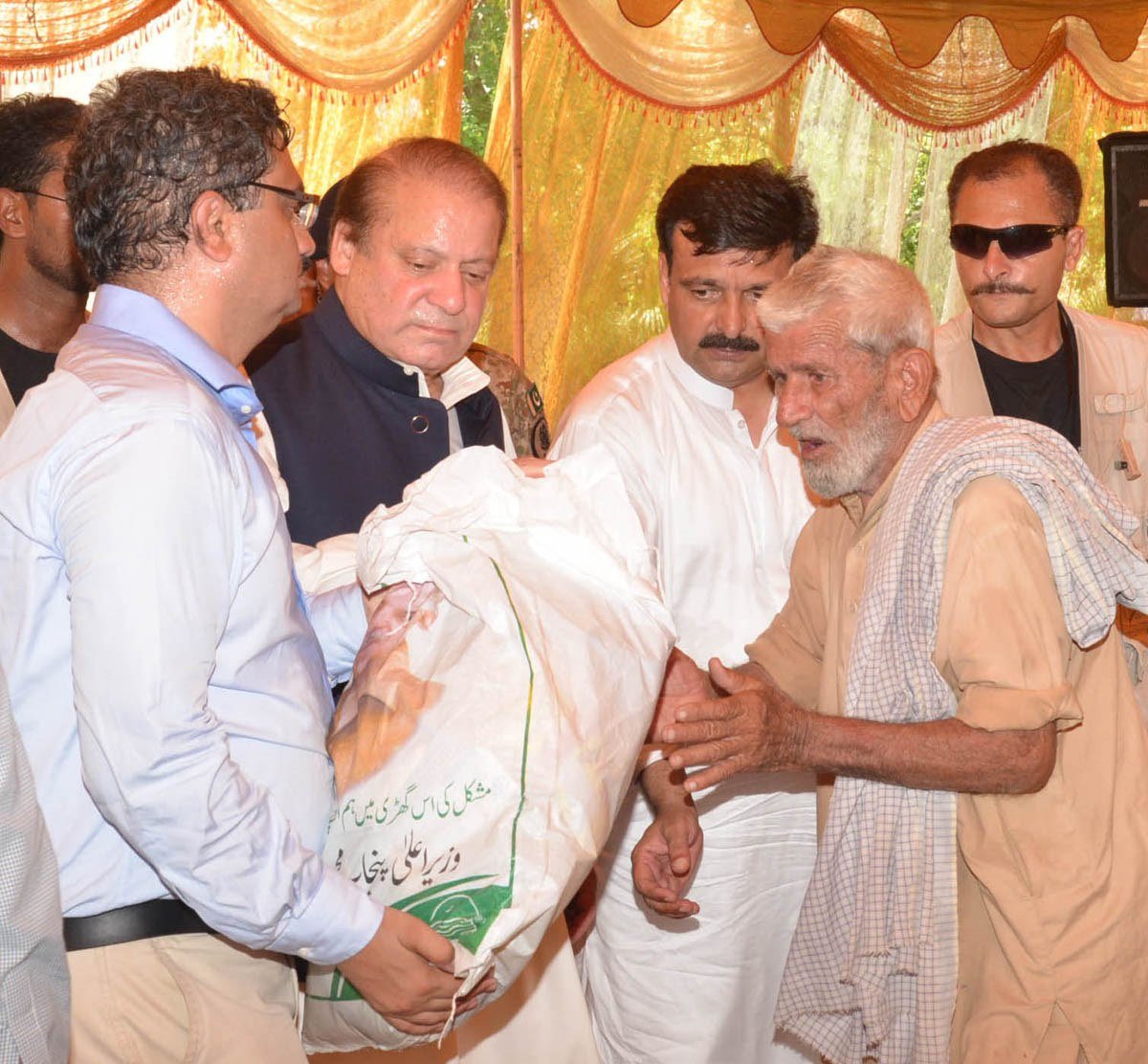 prime minister nawaz sharif distributes ration among flood victims of essa khel mianwali on august 8 2015 photo pid