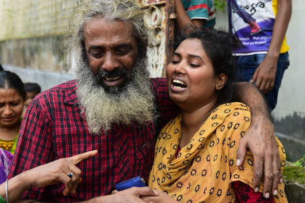 asha moni r the wife of murdered bangladeshi blogger niloy chakrabarti who used the pen name niloy neel weeps outside her home in dhaka on august 8 2015 photo afp