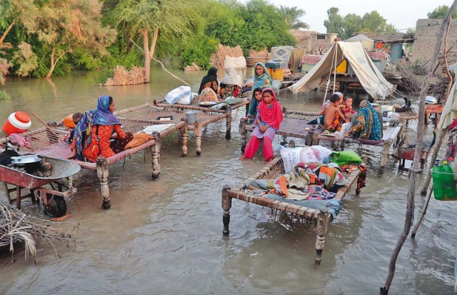 residents of the katcha area near sukkur wait for rescue teams to evacuate them to relief camps as the flood water has devastated their village photo inp