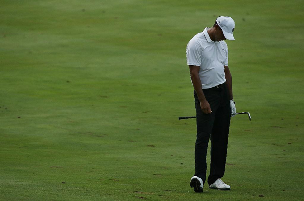 tiger woods reacts to his second shot on the 15th hole during the first round of the quicken loans national at the robert trent jones golf club photo afp