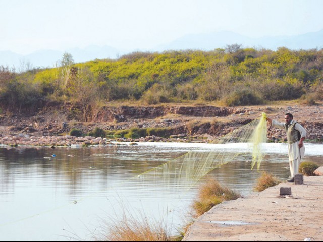 a man drops a net into the korang river photo huma chaudhary express