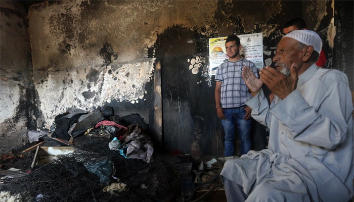 mohammed the father of saad dawabsha a palestinian man who was killed alongside his toddler when their house was firebombed by jewish extremists on july 31 2015 prays at the family 039 s burnt out home in the west bank village of duma photo afp