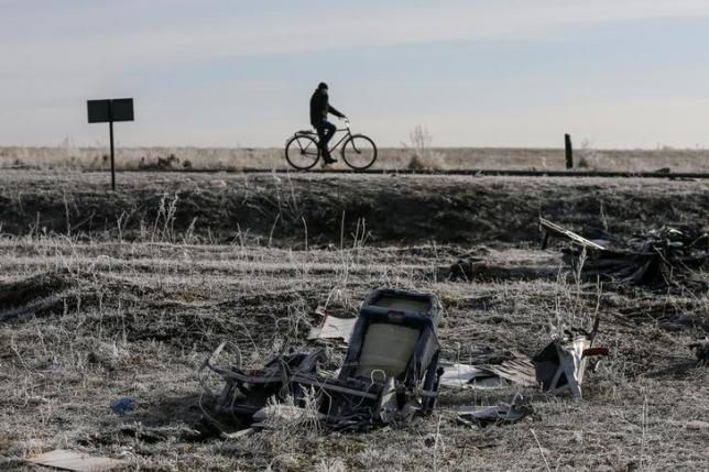 a man rides his bicycle past the wreckage of the malaysia airlines flight mh17 near the village of hrabove grabovo in donetsk region in this december 15 2014 photo reuters