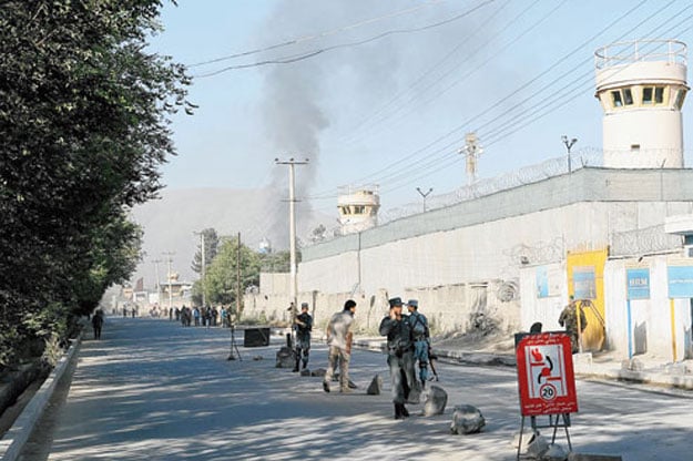 afghan security forces watch as smoke rises from the entrance gate of the presidential palace in kabul photo afp