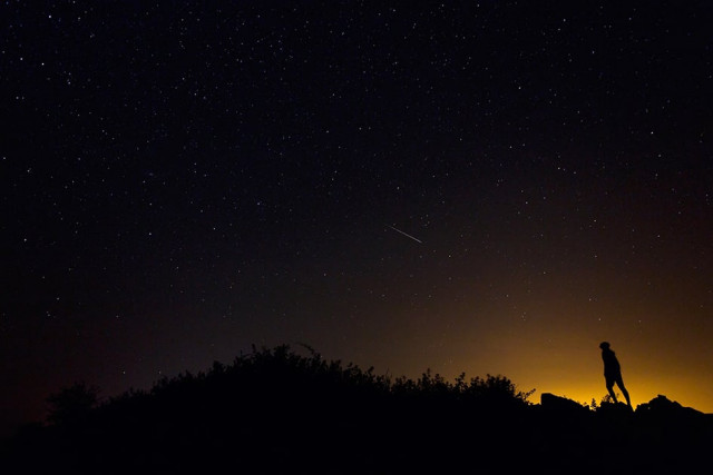 a perseid meteor along the milky way illuminates the dark sky near villadiego in the province of burgos northern spain during the quot perseids quot meteor shower on august 12 2015 photo afp