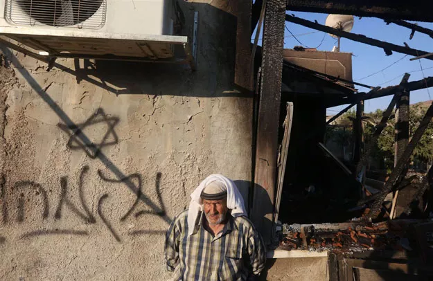 a palestinian man stands next to hebrew graffiti reading quot revenge quot as he looks at the damage to a house that was set on fire in the west bank village of duma photo afp a palestinian man stands next to hebrew graffiti reading quot revenge quot as he looks at the damage to a house that was set on fire in the west bank village of duma photo afp