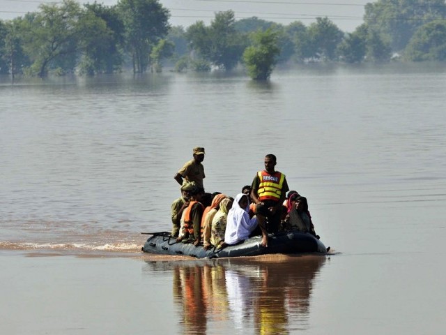 soldiers use an inflatable boat to rescue flood affected residents from a village in punjab photo afp