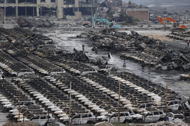 rescuers work at the site of the explosions in tianjin on august 14 2015 enormous explosions in a major chinese port city killed at least 44 people and injured more than 500 state media reported on august 13 leaving a devastated industrial landscape of incinerated cars toppled shipping containers and burnt out buildings photo afp