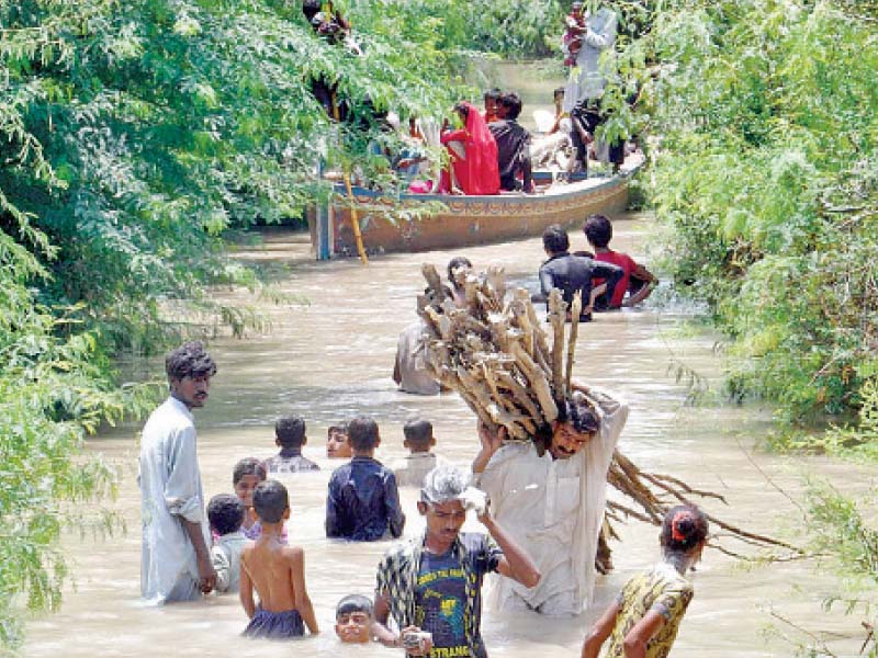 residents of latifabad no 10 hyderabad carry their essentials as floodwater entered the locality situated in the katcha riverine area on saturday photo nni