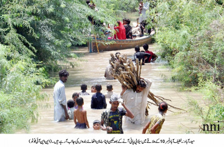 people going to safe areas with belongings after flood water inundated the latifabad area in hyderabad on august 15 photo nni
