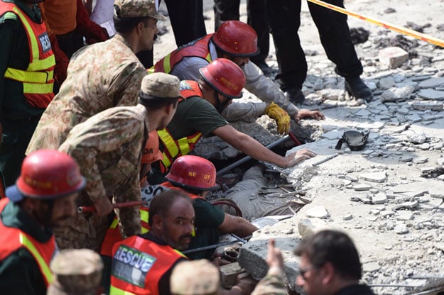 rescuers gather at the site of a blast at punjab home minister shuja khanzada 039 s political office in attock on august 16 2015 photo afp