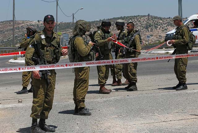 israeli security forces stand in a security perimeter where a young palestinian man was shot and wounded by israeli troops after he stabbed a soldier on august 15 2015 near the quot bel quot crossing on highway 443 near the west bank village of beit ur photo afp