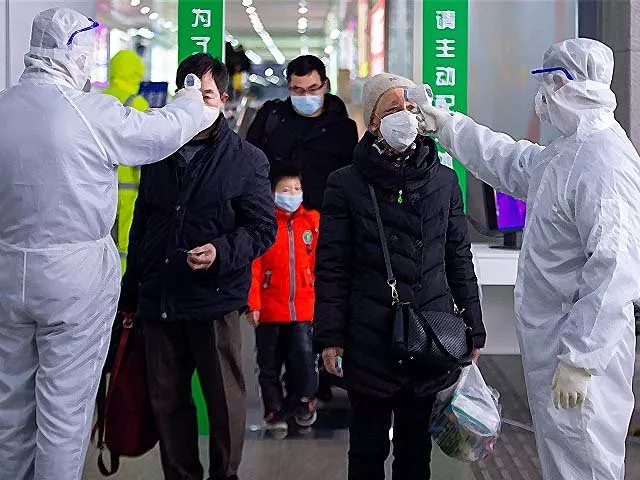 government workers check the temperature of travellers at the exit of a railway station in nanjing photo getty government workers check the temperature of travellers at the exit of a railway station in nanjing photo getty