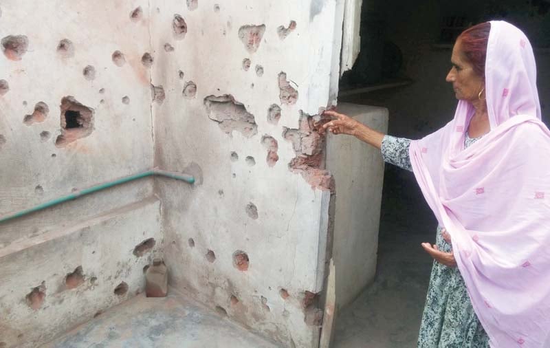 an old woman shows her house damaged by indian shelling photo inp