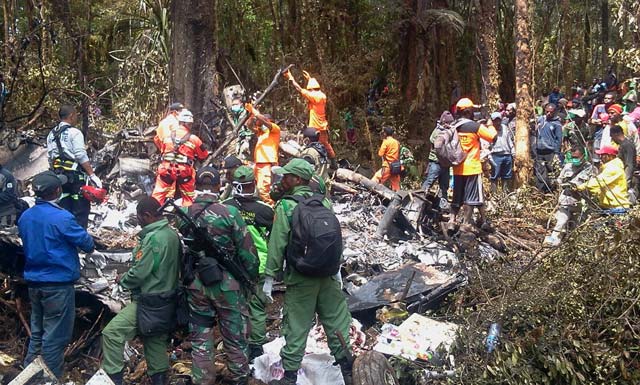 in this photograph taken on august 18 2015 indonesian rescuers search through the wreckage of the trigana air atr 42 300 twin turboprop plane at the crash site in the mountainous area of ogbape near oksibil district located in papua province photo afp
