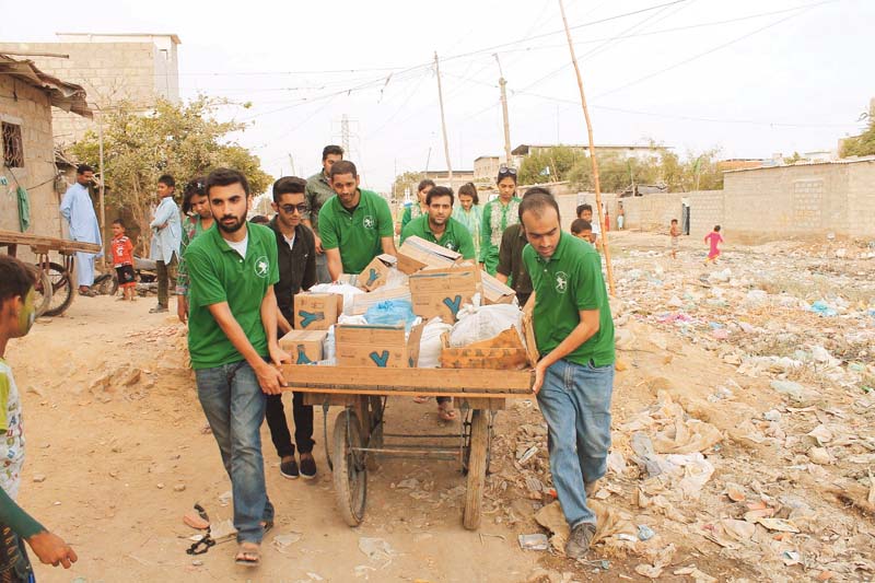 volunteers from the robin hood army in pakistan distributing food to the residents of bilal colony in karachi photo credit abbas mahmud