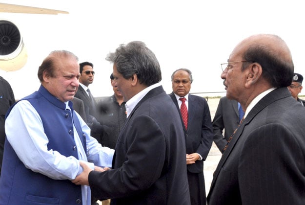 prime minister nawaz sharif l shakes hands with sindh governor ishratul ibad khan c upon his arrival at the karachi airport on a one day visit to the metropolis photo pid