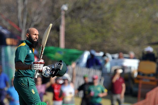 south african batsman hashim amla raises his bat and helmet as he celebrates scoring a century 100 runs during the first one day international match between south africa and new zealand on august 19 2015 in centurion south africa photo afp