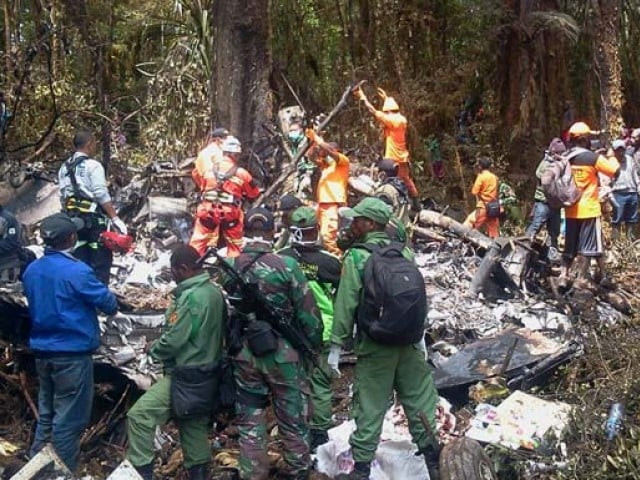 in this photograph taken on august 18 2015 indonesian rescuers search through the wreckage of the trigana air atr 42 300 twin turboprop plane at the crash site in the mountainous area of ogbape near oksibil district located in papua province photo afp