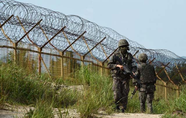 south korean soldiers keeping watch near the scene where planted landmines exploded on august 4 maiming two soldiers on border patrol in the demilitarized zone photo afp