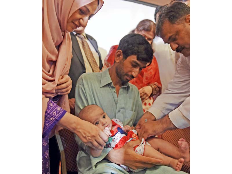 state minister for national health services regulation and coordination saira afzal tarar watches as a doctor administers ipv to a child photo afp