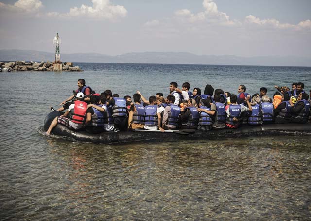 a dinghy carrying afghan syrian and iranian migrants arrives in the port of the village of sikaminea on the greek island of lesbos on august 20 2015 photo afp