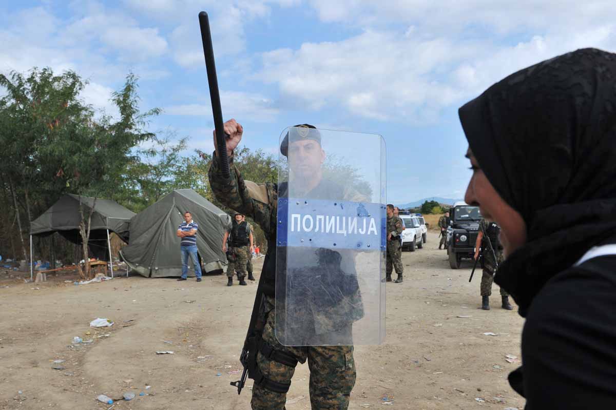 a migrant girlclashes with a macedonian police officer near the town of idomeni northern greece on august 21 2015 photo afp