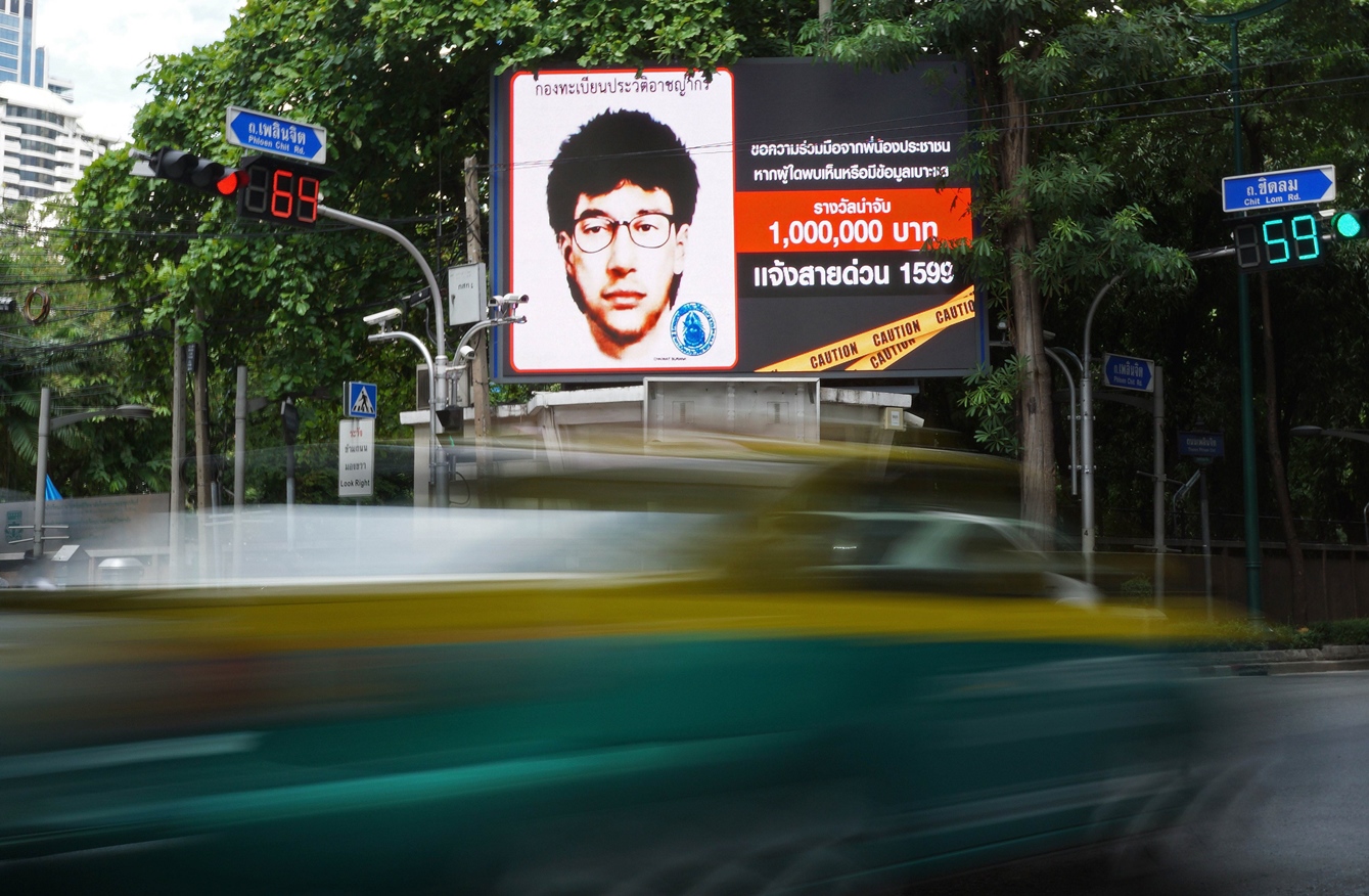 vehicles pass by a digital billboard showing the sketch of a man suspected to be the bangkok bomber in central bangkok on august 22 2015 photo afp