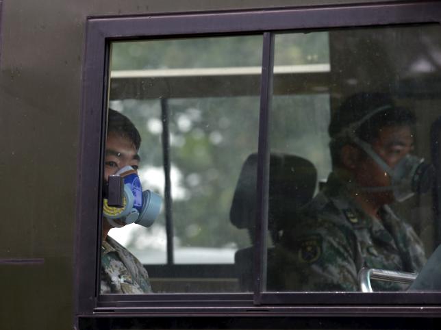 paramilitary policemen wearing masks ride a vehicle as they travel within a 3 km 2 mile exclusion zone from last week 039 s explosion site in binhai new district in tianjin china august 18 2015 photo reuters