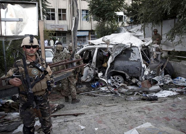 afghan security personnel l keeps watch next to a damaged car belonging to foreigners after a bomb blast in kabul afghanistan august 22 2015 photo reuters