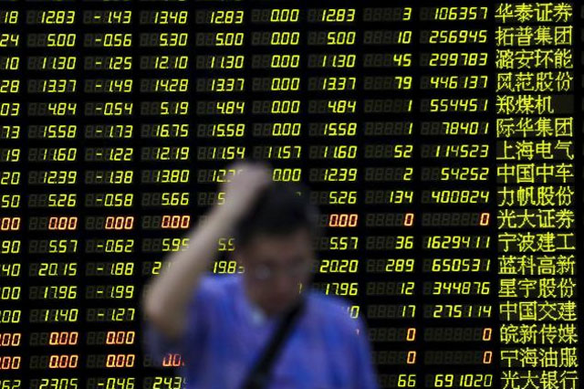 an investor stands in front of an electronic board showing stock information at a brokerage house in shanghai china august 24 2015 photo reuters