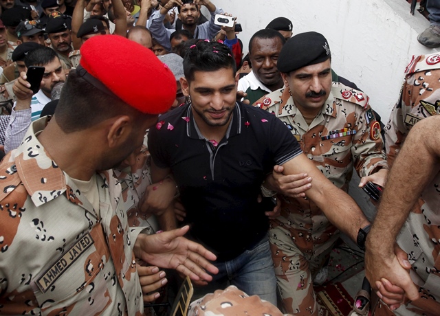 british boxer amir khan of pakistani origin is escorted by rangers during his visit to the peoples football stadium in karachi pakistan photo reuters