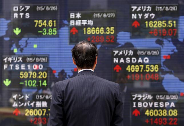 a pedestrian looks at an electronic board showing the stock market indices of various countries outside a brokerage in tokyo japan august 27 2015 photo reuters